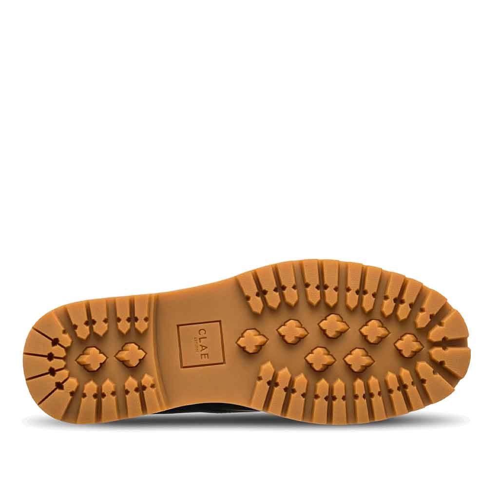Brown sole of a shoe with 'Clae' branding on a white background