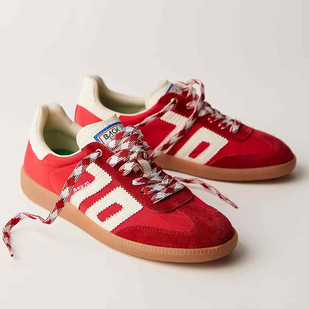 Pair of red sneakers with white accents on a light gray background